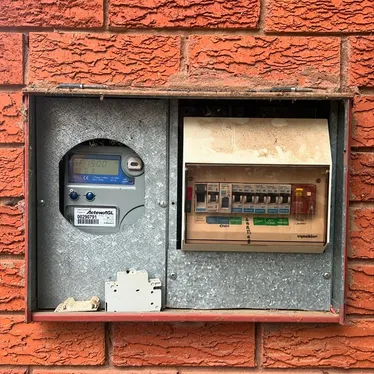 Old switchboard with rewireable ceramic fuses in a brick meter box