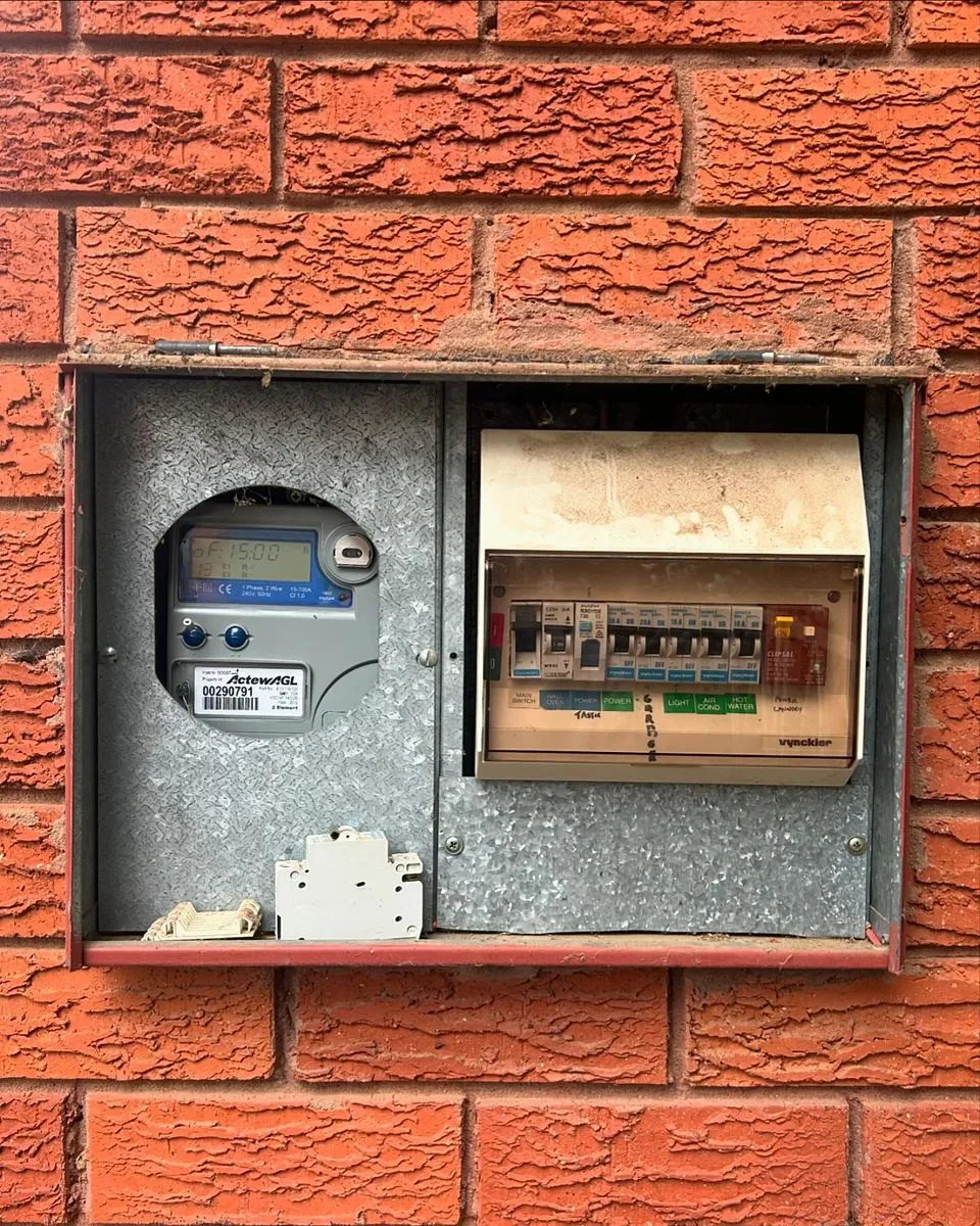 Old switchboard with rewireable ceramic fuses in a brick meter box