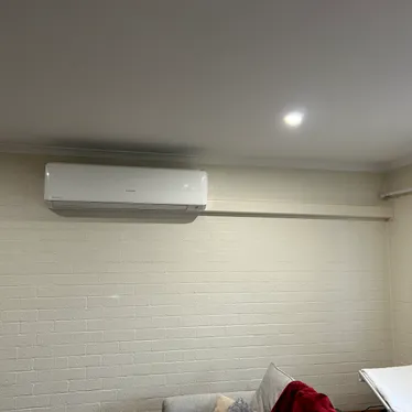 Split system air conditioner indoor unit mounted high on a living room wall
